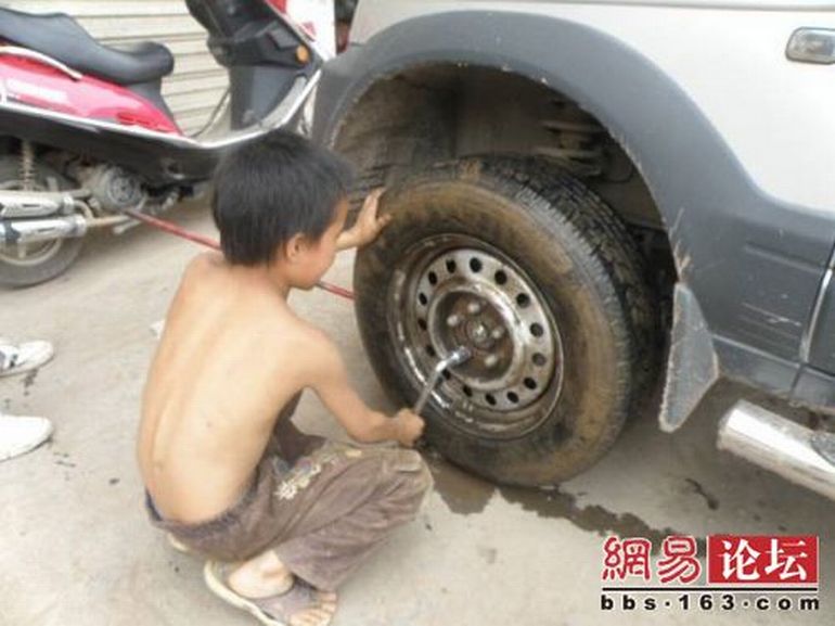 Chinese boy working as a tire repair worker